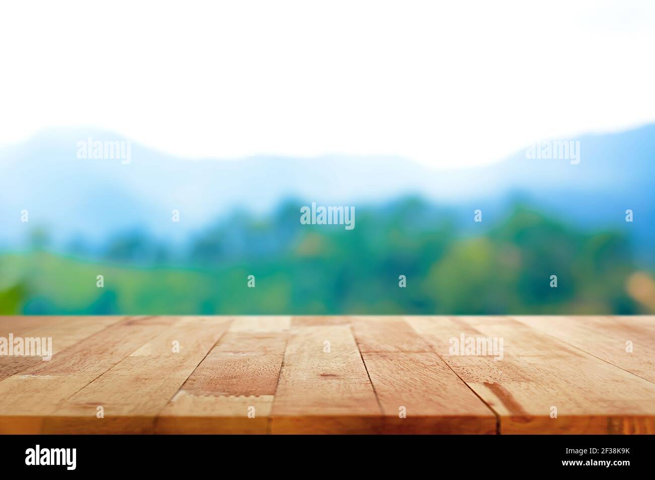 Tavolo in legno su sfondo di montagna sfocata - può essere utilizzato per la visualizzazione o il montaggio dei prodotti Foto Stock