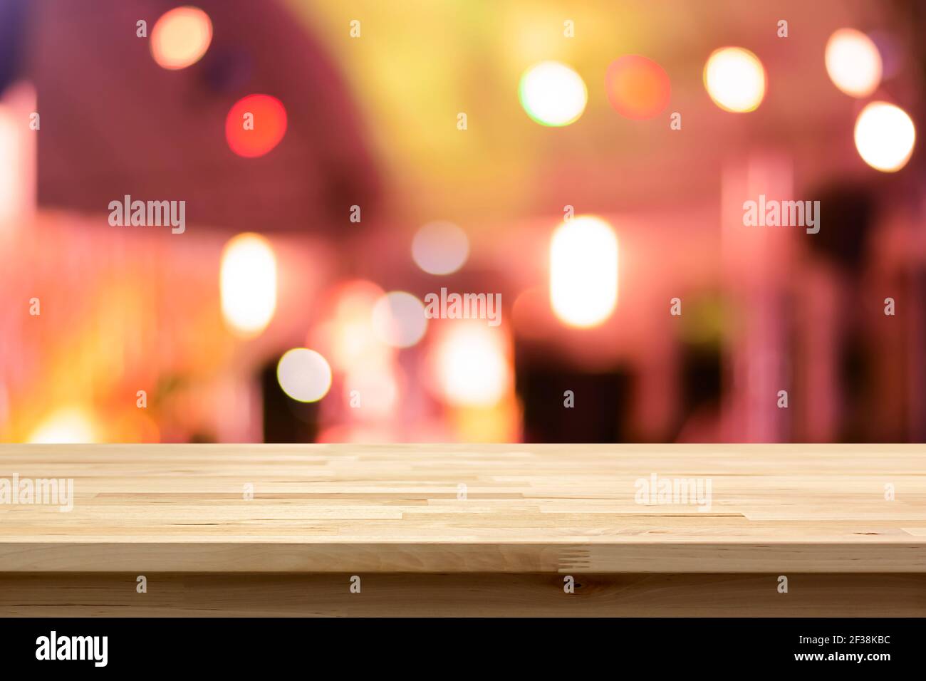Tavolo in legno su sfondo bokeh astratto colorato di notte - può essere utilizzato per il montaggio o la visualizzazione dei prodotti Foto Stock
