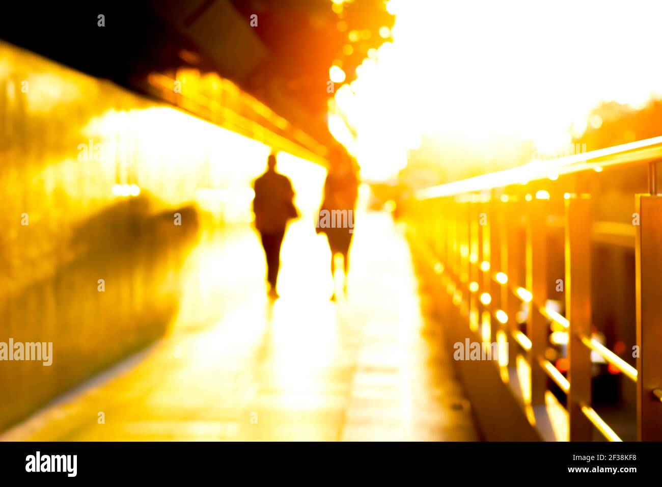 Offuscare la silhouette delle persone che camminano sul vialetto al crepuscolo Foto Stock