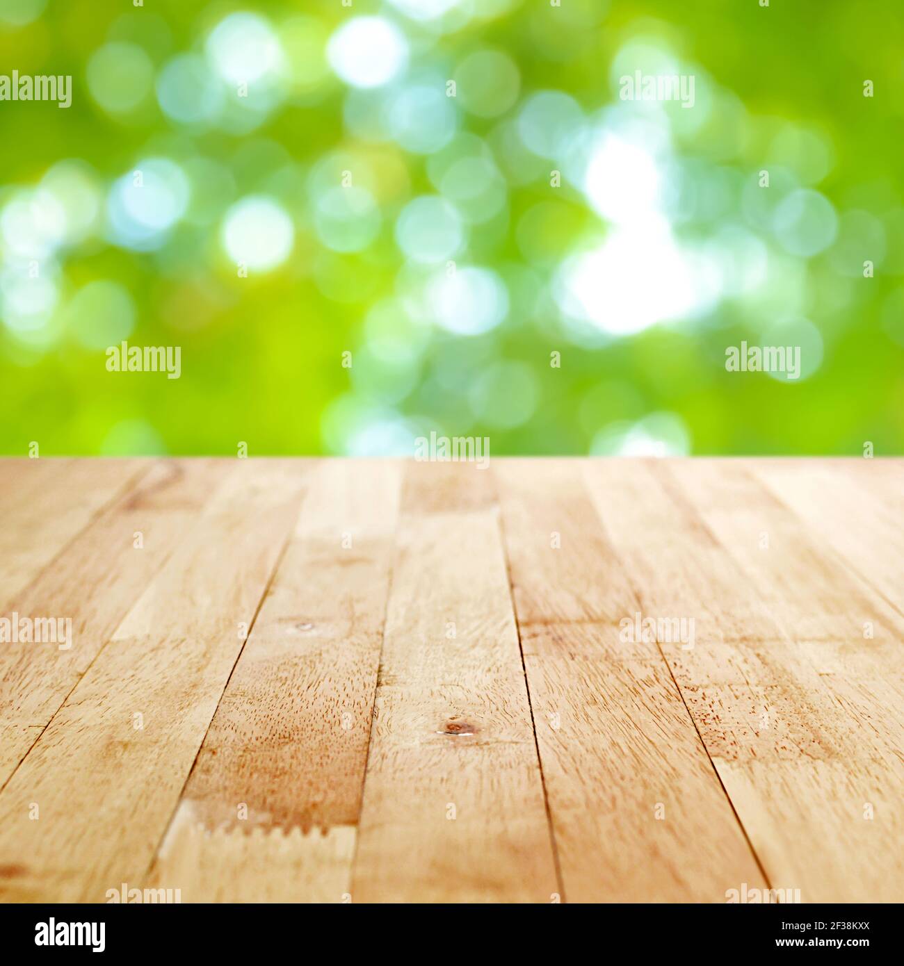 Tavolo in legno su sfondo astratto bokeh verde - CAN essere utilizzato per il montaggio o la visualizzazione dei prodotti Foto Stock