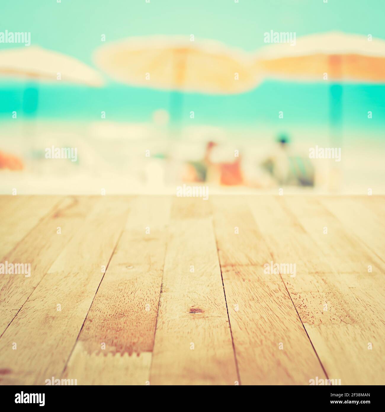 Tavolo in legno sullo sfondo della spiaggia sfocato, concetto di sfondo delle vacanze estive, tonalità vintage - può essere utilizzato per il montaggio o la visualizzazione dei vostri prodotti Foto Stock