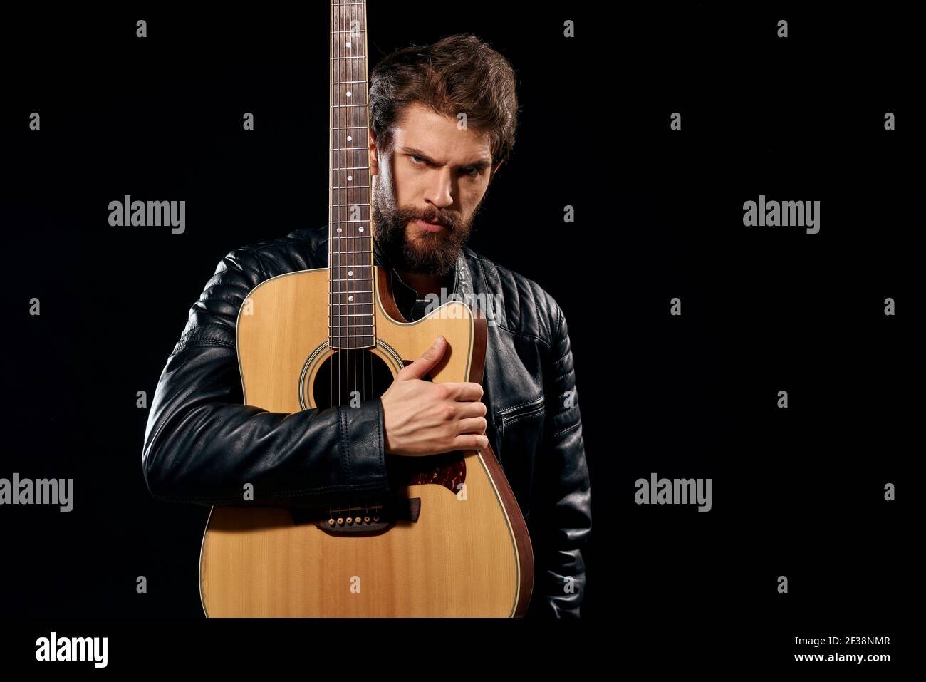 Un uomo con una chitarra in mano giacca in pelle musica performance rock  star stile moderno sfondo scuro Foto stock - Alamy