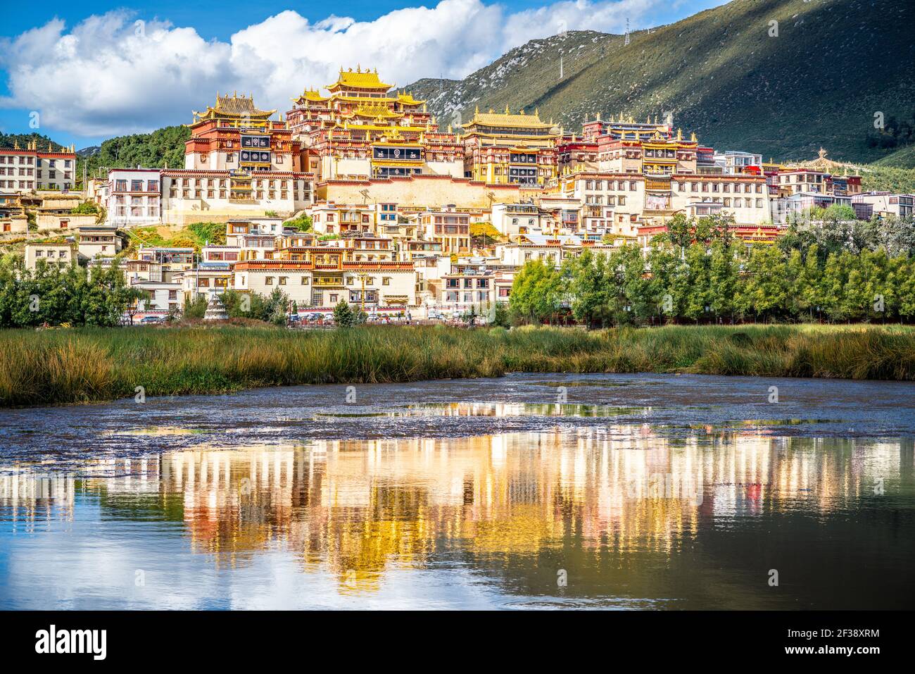 Ganden Sumtseling monastero con bella riflessione d'acqua sul lago in Shangri-la Yunnan Cina Foto Stock