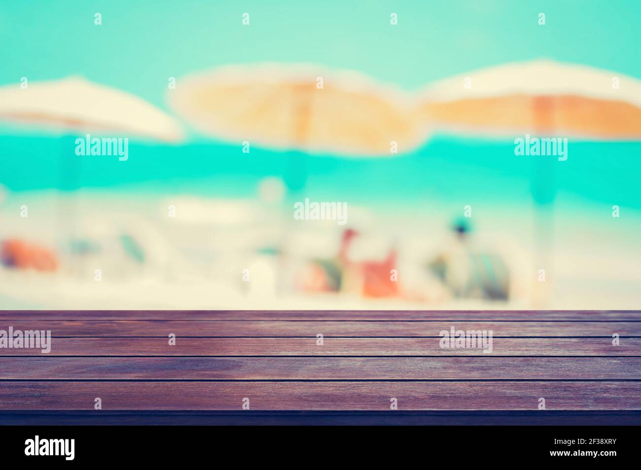 Tavolo in legno su spiaggia offuscata baackground, concetto di sfondo per le vacanze estive, tonalità vintage - può essere utilizzato per il montaggio o la visualizzazione dei vostri prodotti Foto Stock