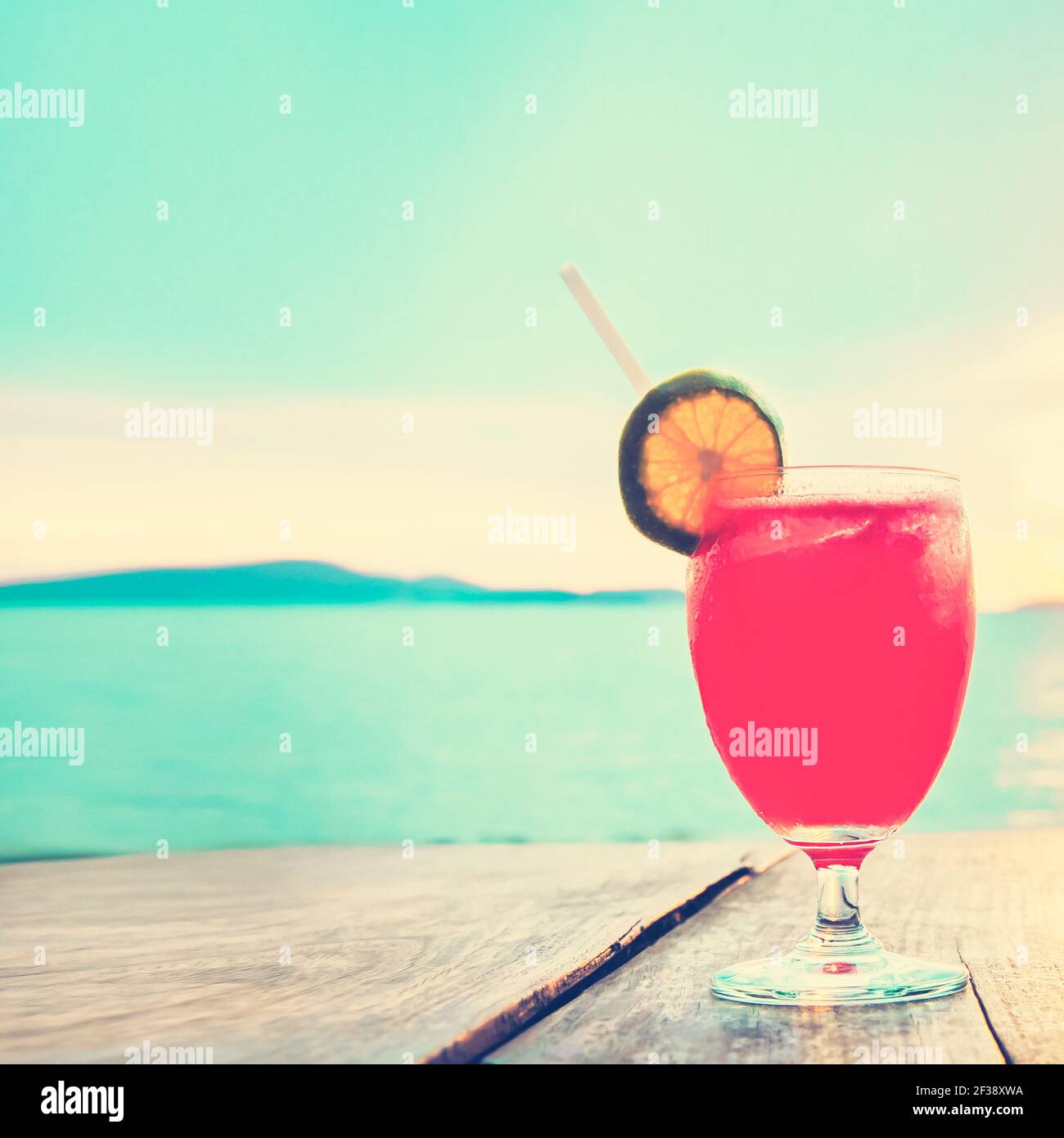 Cocktail drink su tavolo di legno di fronte al mare estivo e cielo di fondo, tonalità vintage - chill out e concetto di vacanza estiva Foto Stock