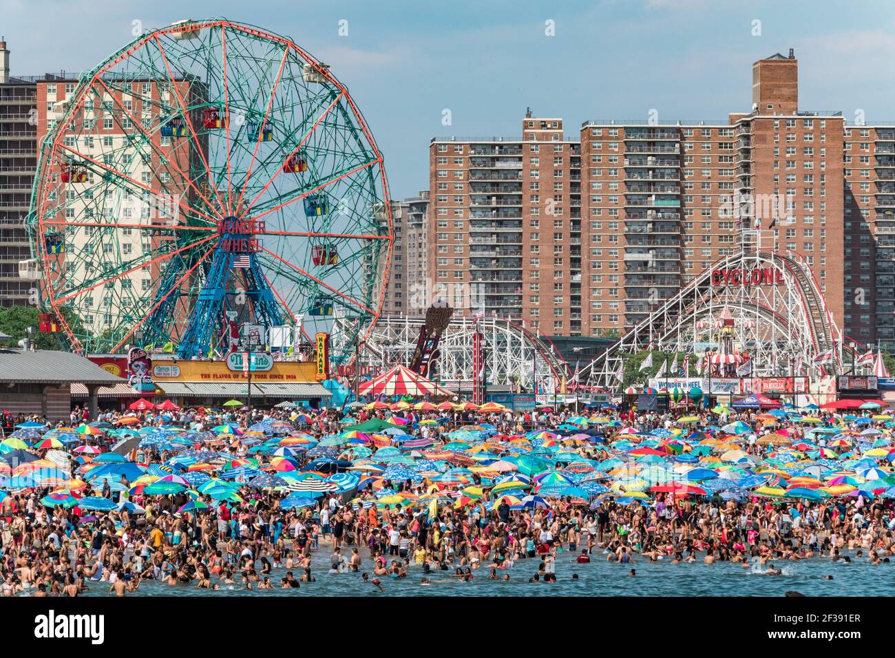 Sciami infiniti di persone e i loro ombrelloni imballano la spiaggia a Coney Island il 4 luglio 2017. Foto Stock