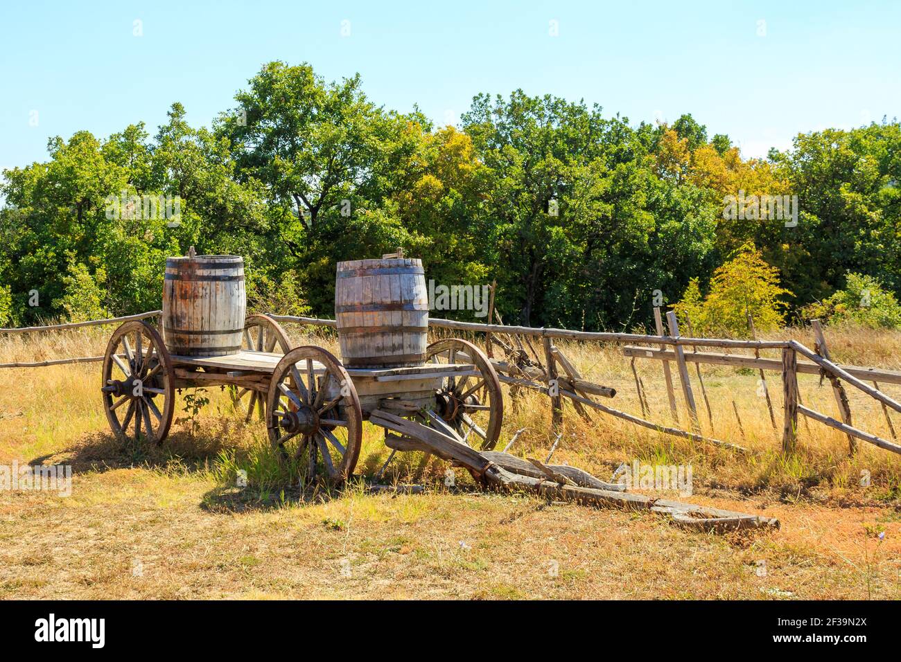 Vecchio vagone di legno caricato con barili in fattoria rurale Foto Stock