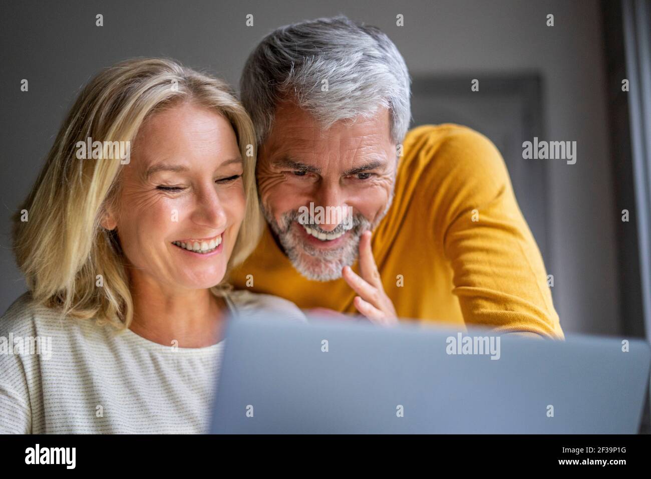 Sorridente Coppia matura utilizzando laptop Foto Stock