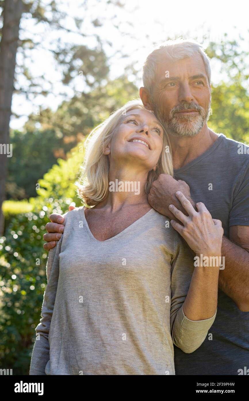 Donna matura sorridente che guarda suo marito in cortile Foto Stock