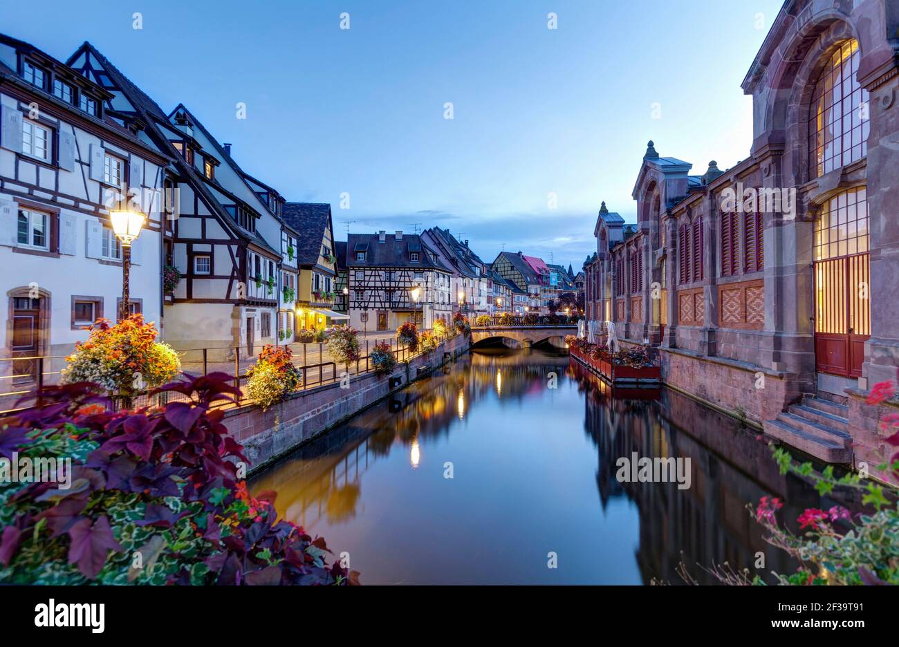 Colmar (Francia nord-orientale): Facciate di case a graticcio, case tradizionali alsaziane, e il mercato coperto di sera lungo il fiume Lauch i. Foto Stock