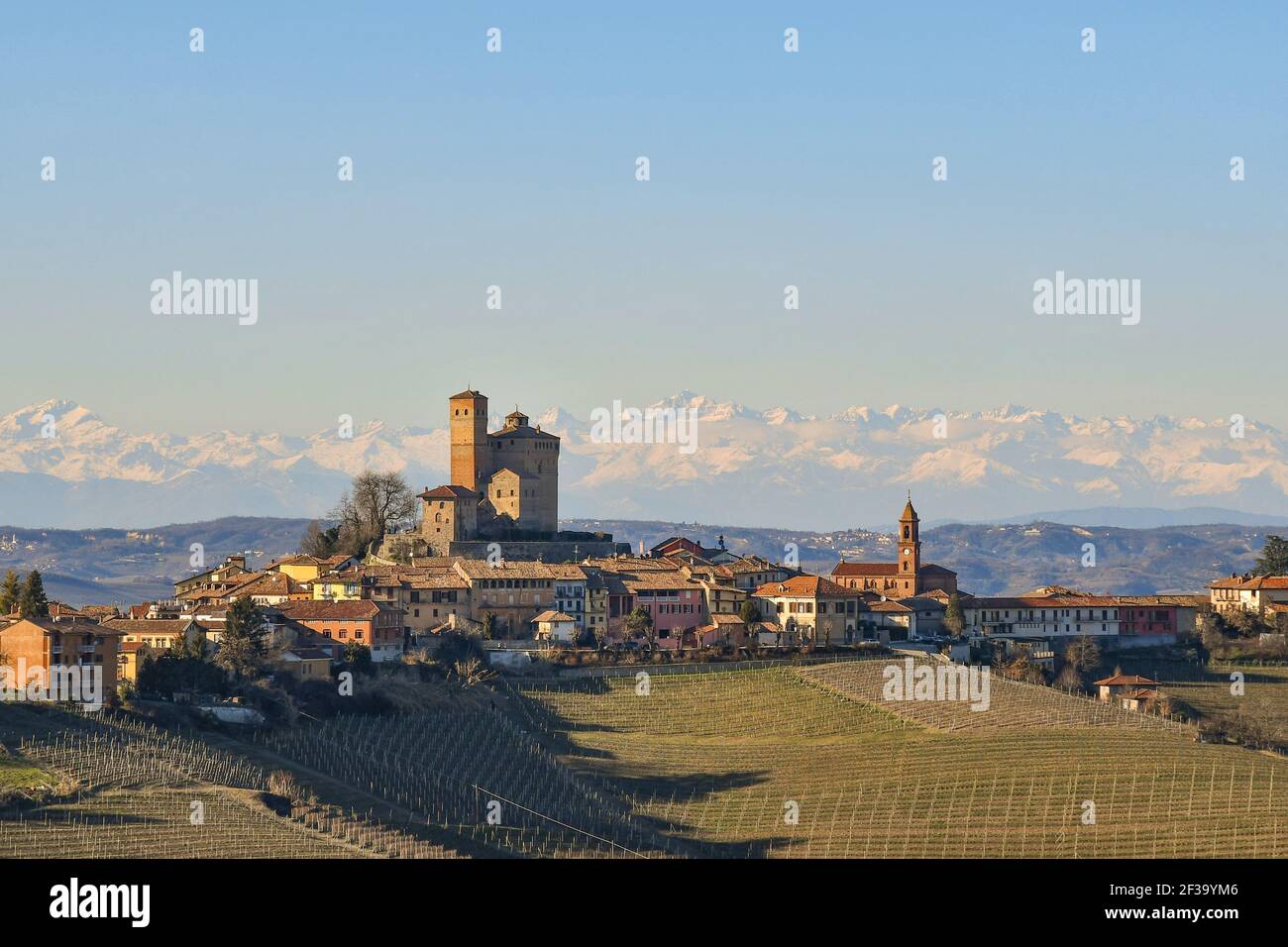 Vista sulle colline delle Langhe, patrimonio dell'umanità dell'UNESCO, con il borgo medievale di Serralunga d'Alba e le montagne delle Alpi, Cuneo, Piemonte, Italia Foto Stock