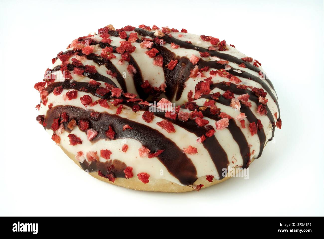 Ciambella smaltata con glassa bianca e cioccolato e cosparsa di pezzi di frutta isolati su bianco Foto Stock
