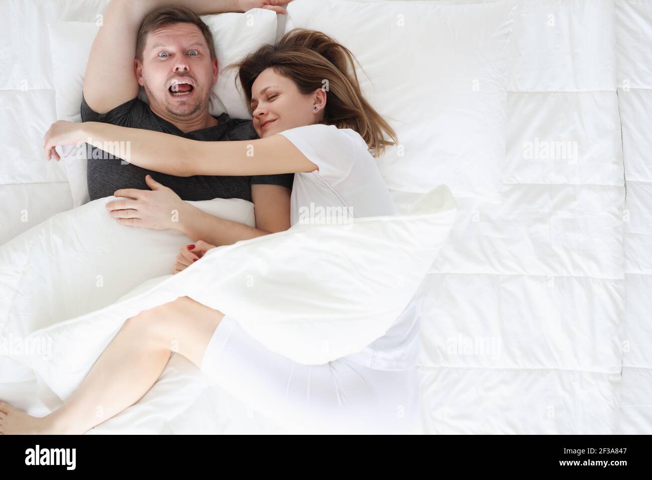 Donna che dorme sull'uomo nella vista dall'alto del letto Foto Stock