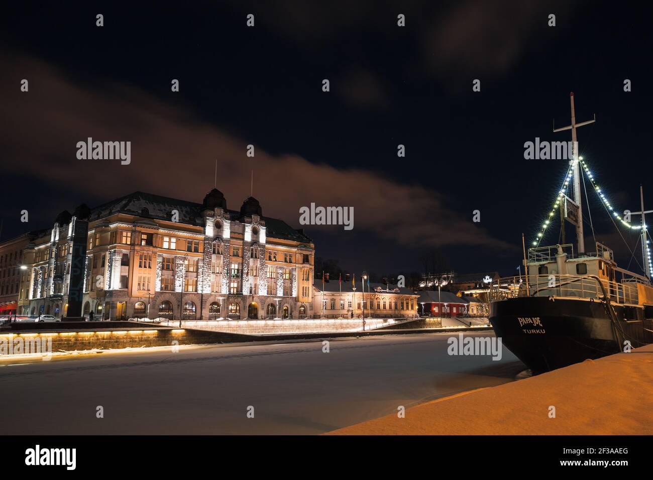 Turku, Finlandia - 21 gennaio 2016: Paesaggio urbano di Turku nella notte invernale. Case illuminate e navi lungo la costa del fiume Foto Stock Turku, Finlandia - 21 gennaio 2016: Paesaggio urbano di Turku nella notte invernale. Case illuminate e navi lungo la costa del fiume Foto Stock