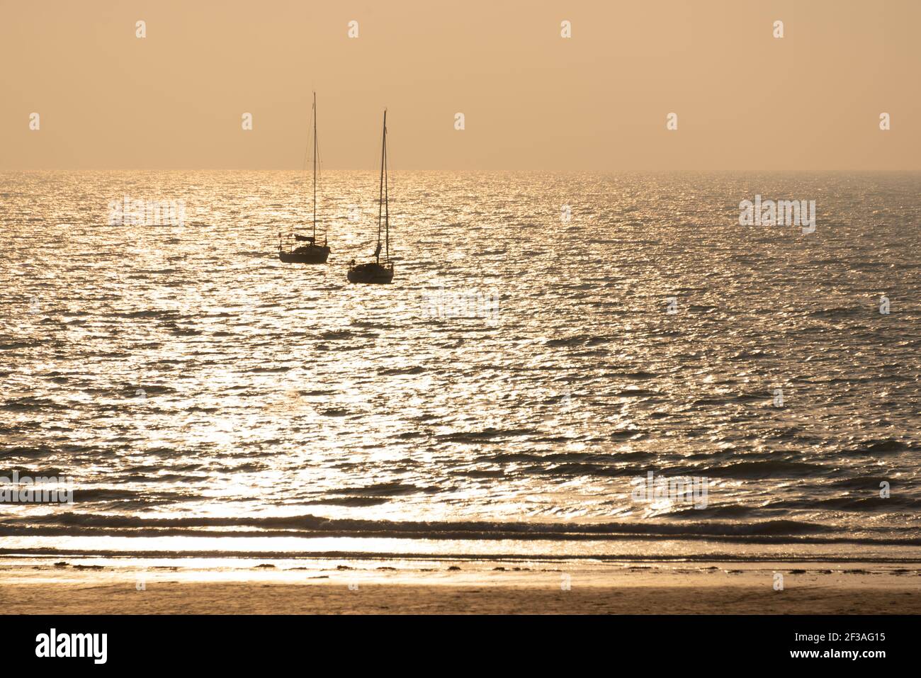 Silhouette di barche a vela al tramonto su una spiaggia di Pléneuf, Côtes d'Armor, Britanny, Francia Foto Stock
