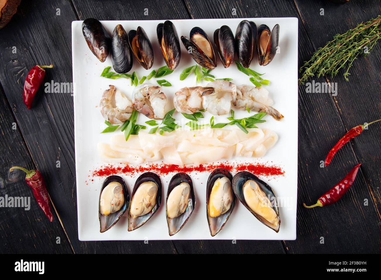 Piatto di pesce assortito sul tavolo di legno scuro Foto Stock