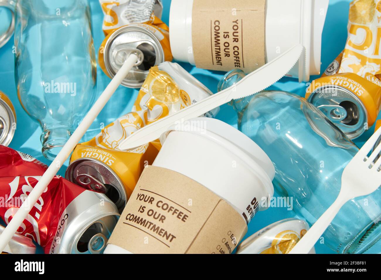 BANGKOK, THAILANDIA - 16 MARZO 2021: Rumpled singha limone soda Coca Cola lattine su sfondo blu Foto Stock