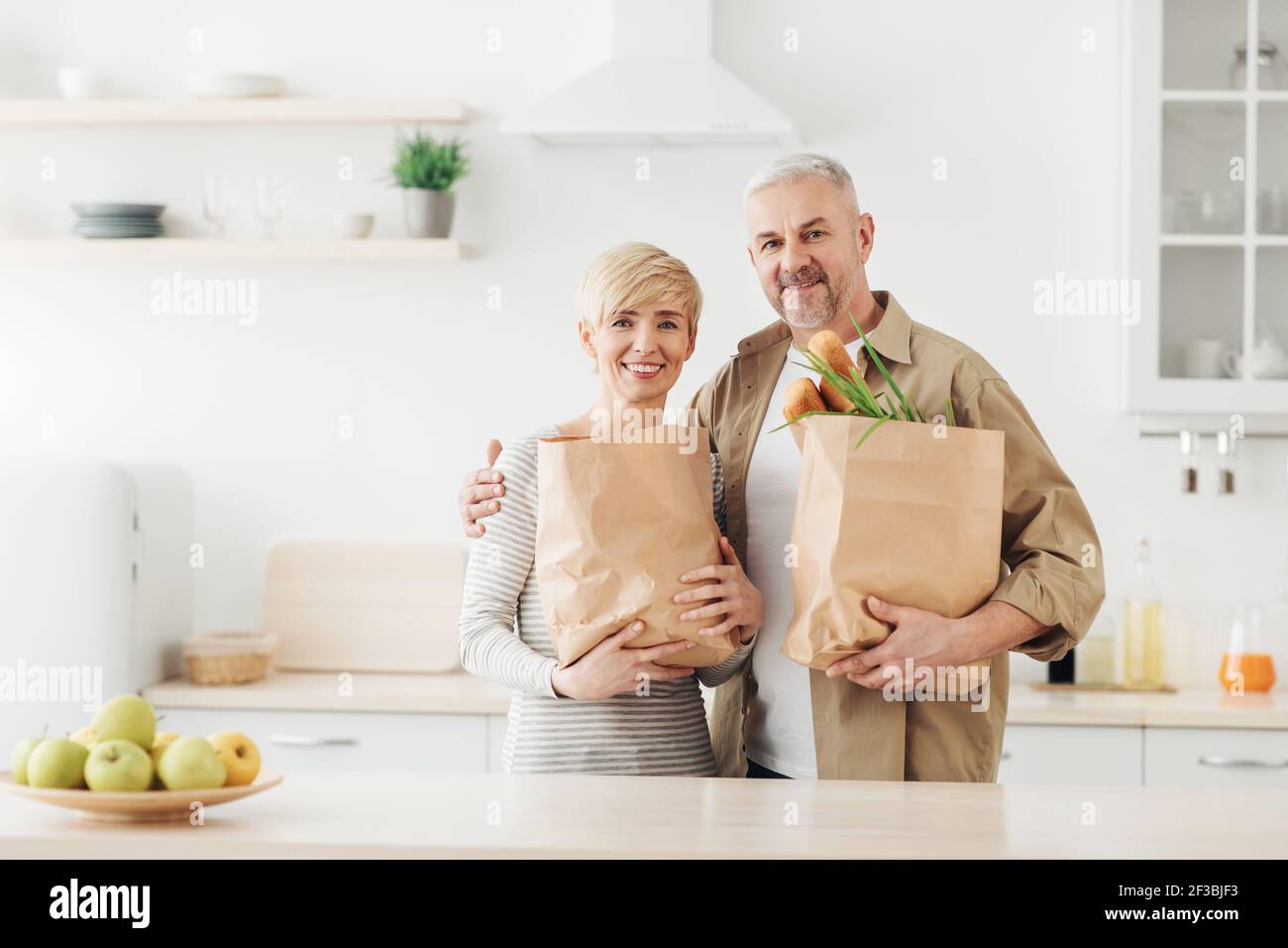 Uno stile di vita sano, un rapporto felice per l'uomo e la donna di mezza età, prodotti per lo shopping insieme Foto Stock