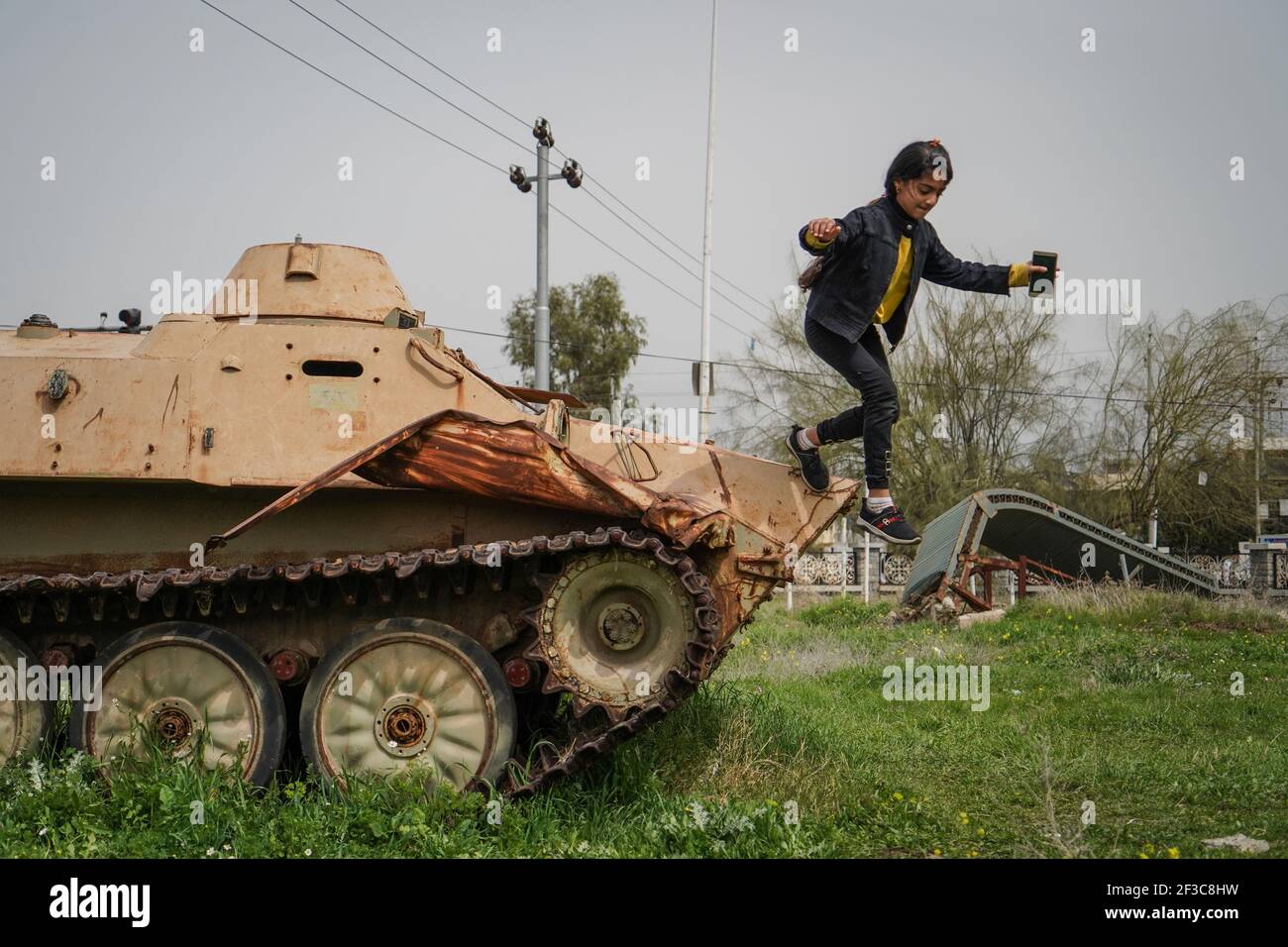 Halabja, Iraq. 16 Marzo 2021. Un bambino che visita il monumento di Halabja gioca sulla cima di un veicolo militare che è stato usato nell'attacco chimico effettuato dal governo iracheno il 16 marzo 1988 durante i giorni di chiusura della guerra Iran·Iraq nella città curda di Halabja, che ha ucciso quasi 5000 persone e ha ferito circa 10000 persone, la maggior parte erano civili. Credit: Ismael Adnan/dpa/Alamy Live News Foto Stock