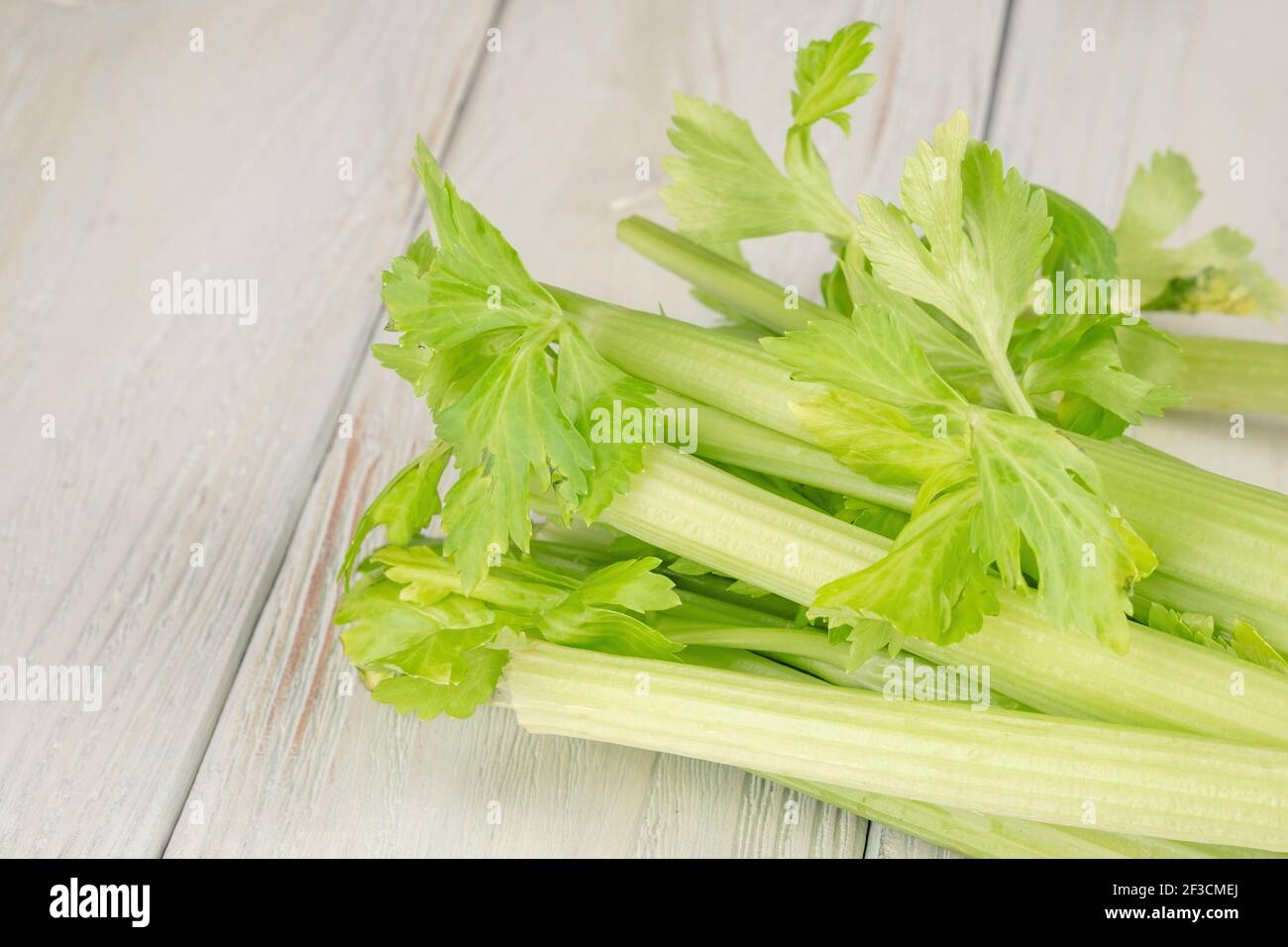 Mazzetto di sedano fresco con foglie su un legno sfondo Foto Stock