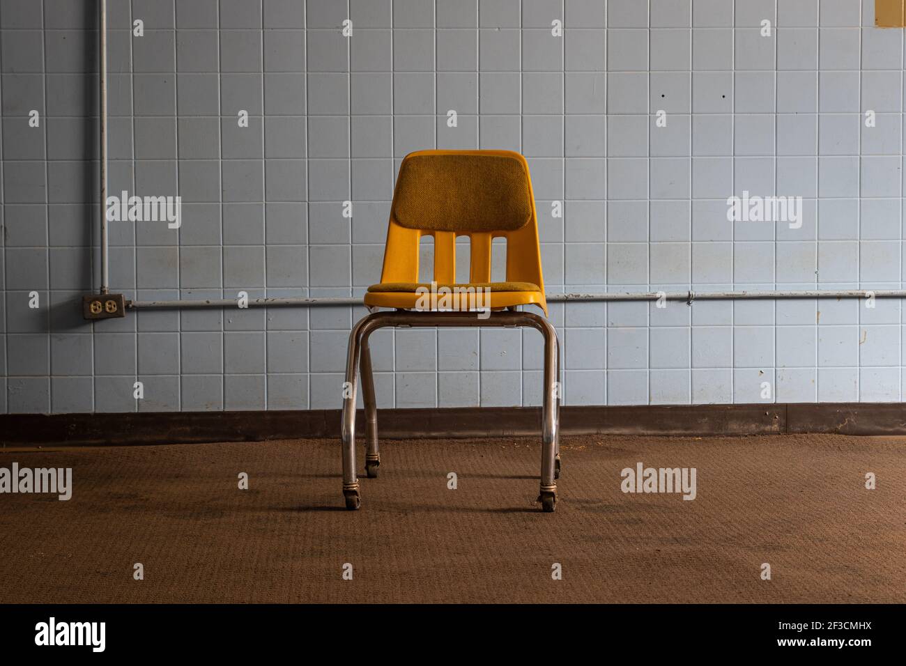 Una sedia gialla all'interno di una stanza blu. Foto Stock