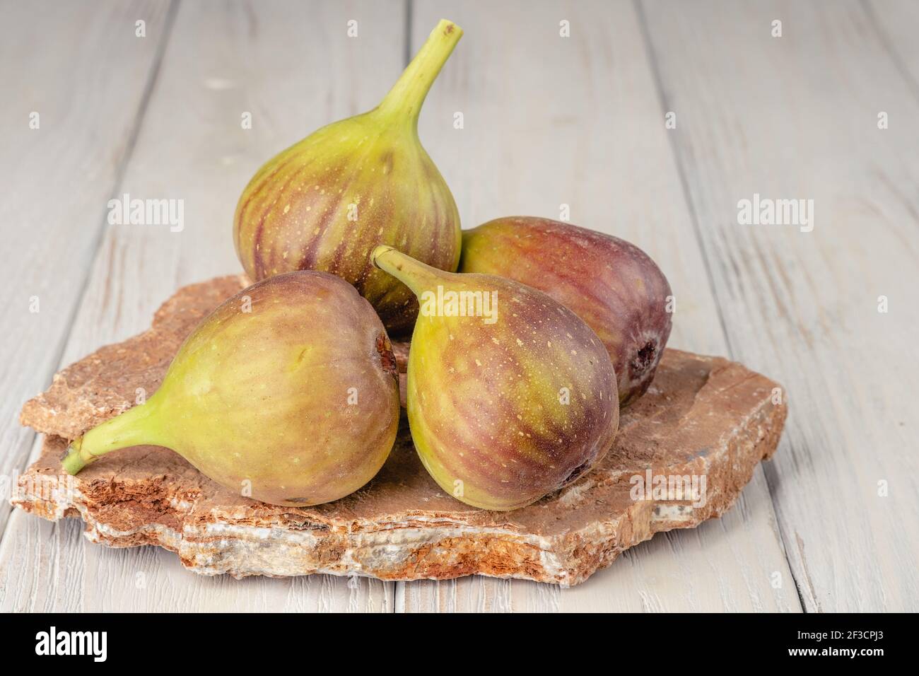 Fichi freschi, leggeri e sani su sfondo bianco di legno Foto Stock