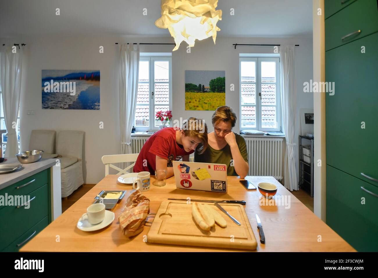 madre con figlio adolescente in cucina guardando sul notebook Foto Stock