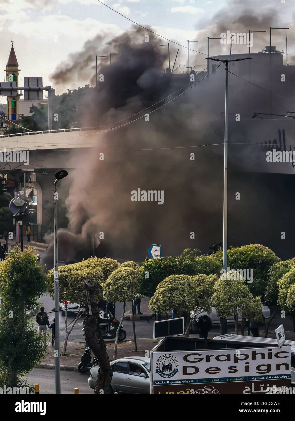 Manifestanti libanesi che bruciano pneumatici a Beirut Airport Highway tagliando il Strada in opposizione sulla crisi economica e libanese Sterlina Calo di valore Foto Stock