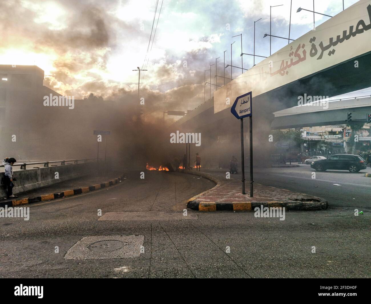 Manifestanti libanesi che bruciano pneumatici a Beirut Airport Highway tagliando il Strada in opposizione sulla crisi economica e libanese Sterlina Calo di valore Foto Stock