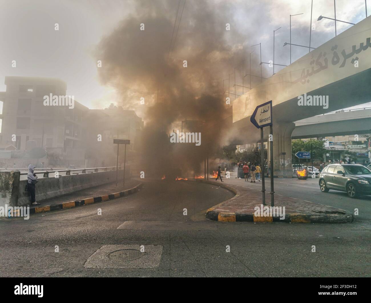 Manifestanti libanesi che bruciano pneumatici a Beirut Airport Highway tagliando il Strada in opposizione sulla crisi economica e libanese Sterlina Calo di valore Foto Stock
