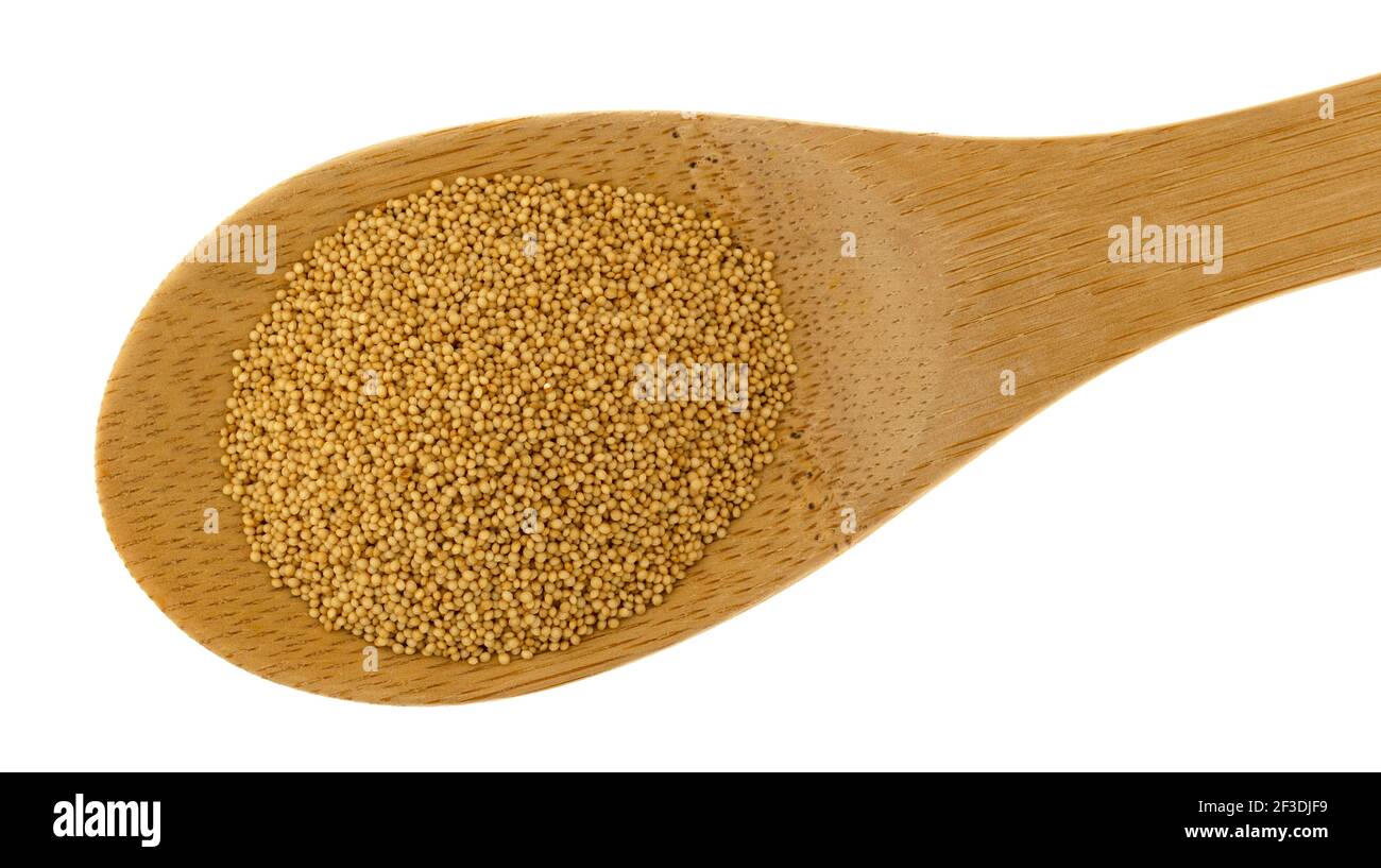 Vista dall'alto del cucchiaio di legno riempito con semi di amaranto su sfondo bianco. Foto Stock