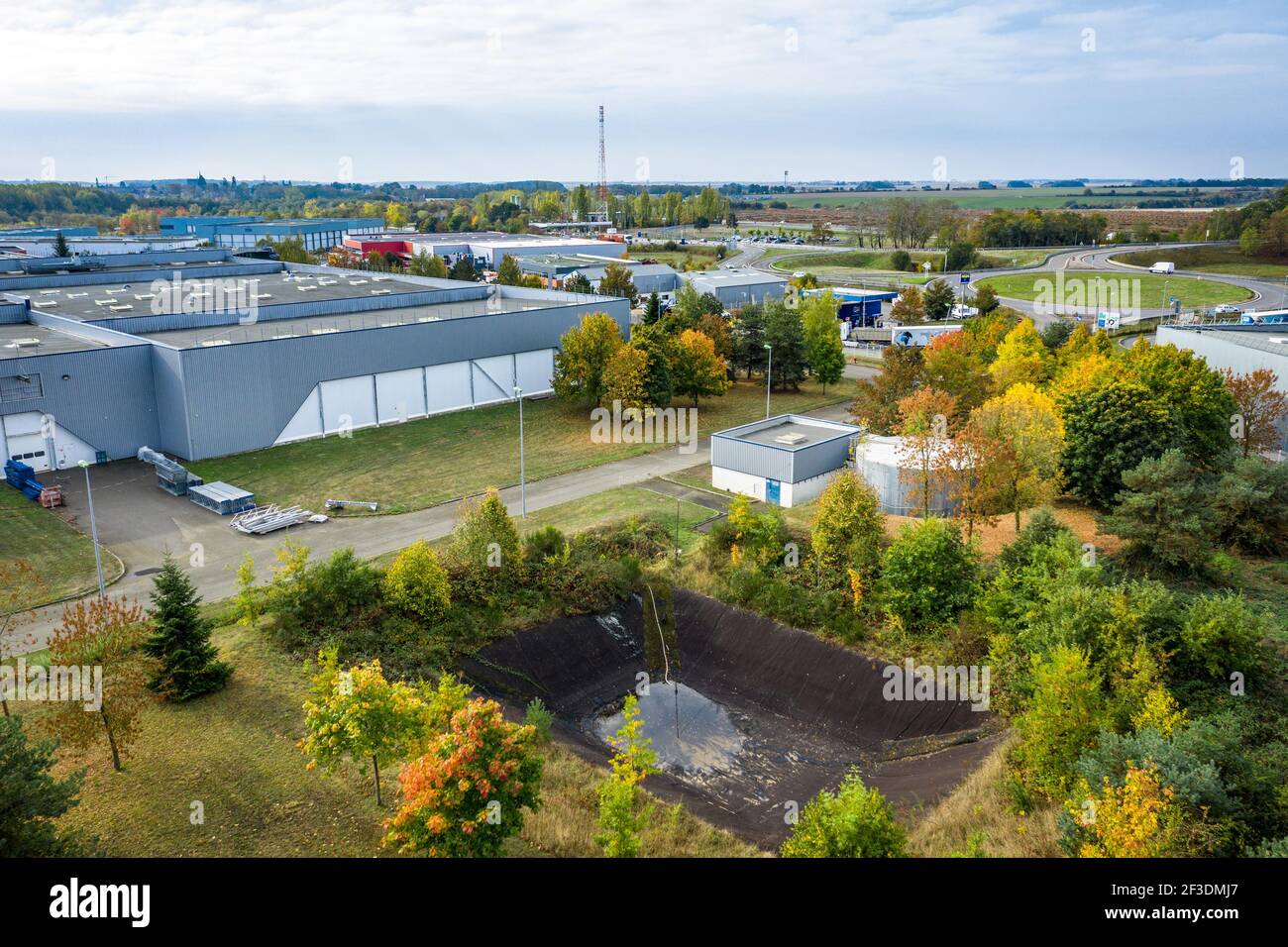 Vista ad alto angolo della struttura ambientale nel parco logistico o industriale. Vaschetta di ritenzione per la raccolta dell'acqua piovana. Industria, trasporti e logistica. Foto Stock