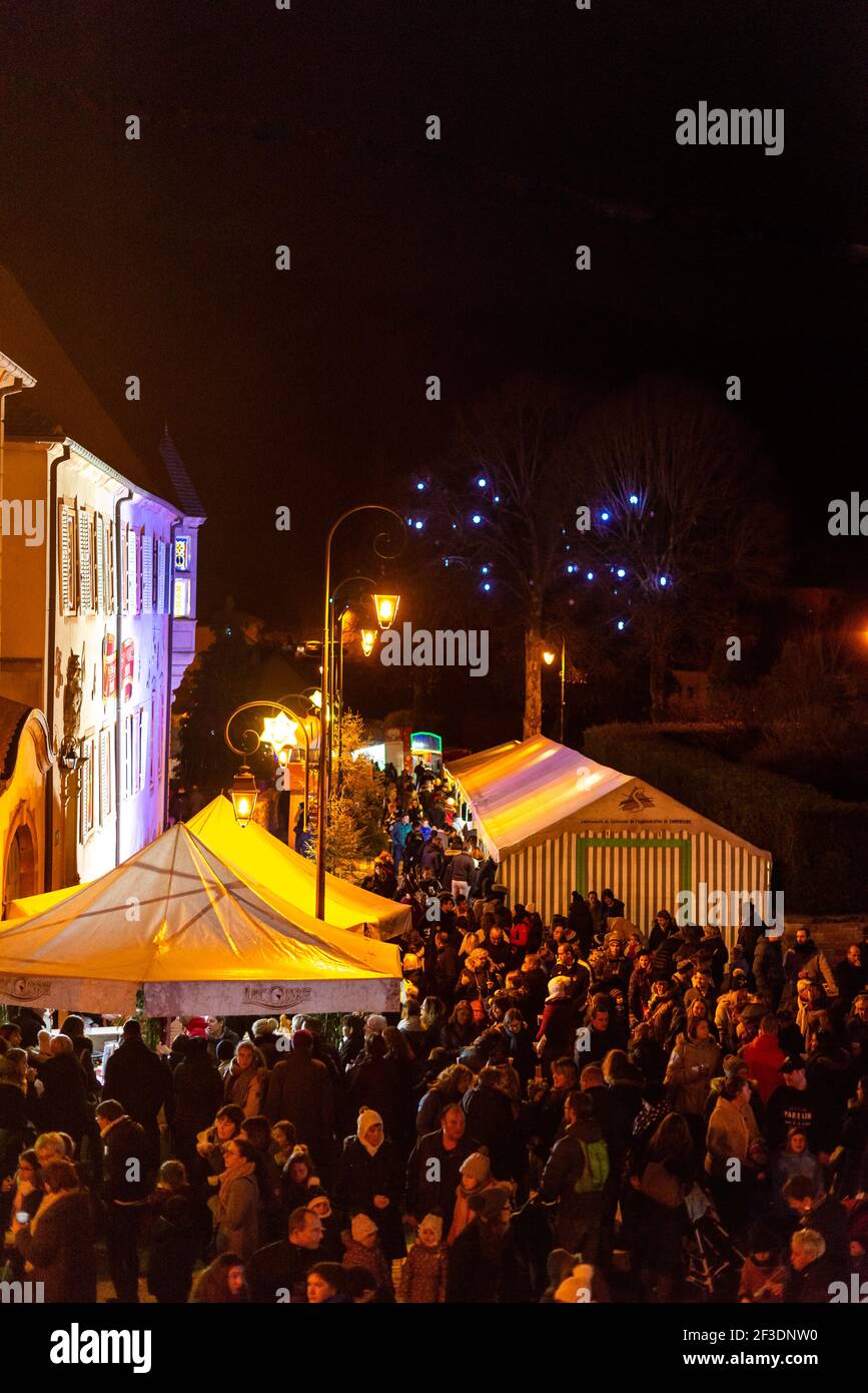 Pubblico occupato nel mercatino di natale shopping di notte nelle strade di Saint quirin , mosella, francia Foto Stock
