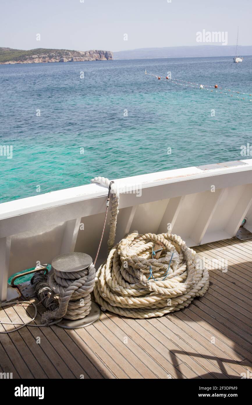 Corda sul ponte di una barca. Mare blu profondo sullo sfondo. La località è Sardegna Foto Stock