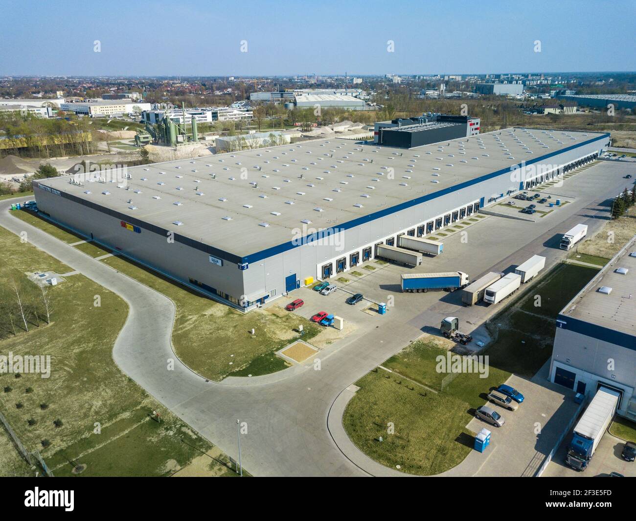 Ore fuori orario di punta nel centro di distribuzione logistica. Vista drone di pochi camion in piedi in un grande magazzino. Concetto di trasporto e logistica. Foto Stock