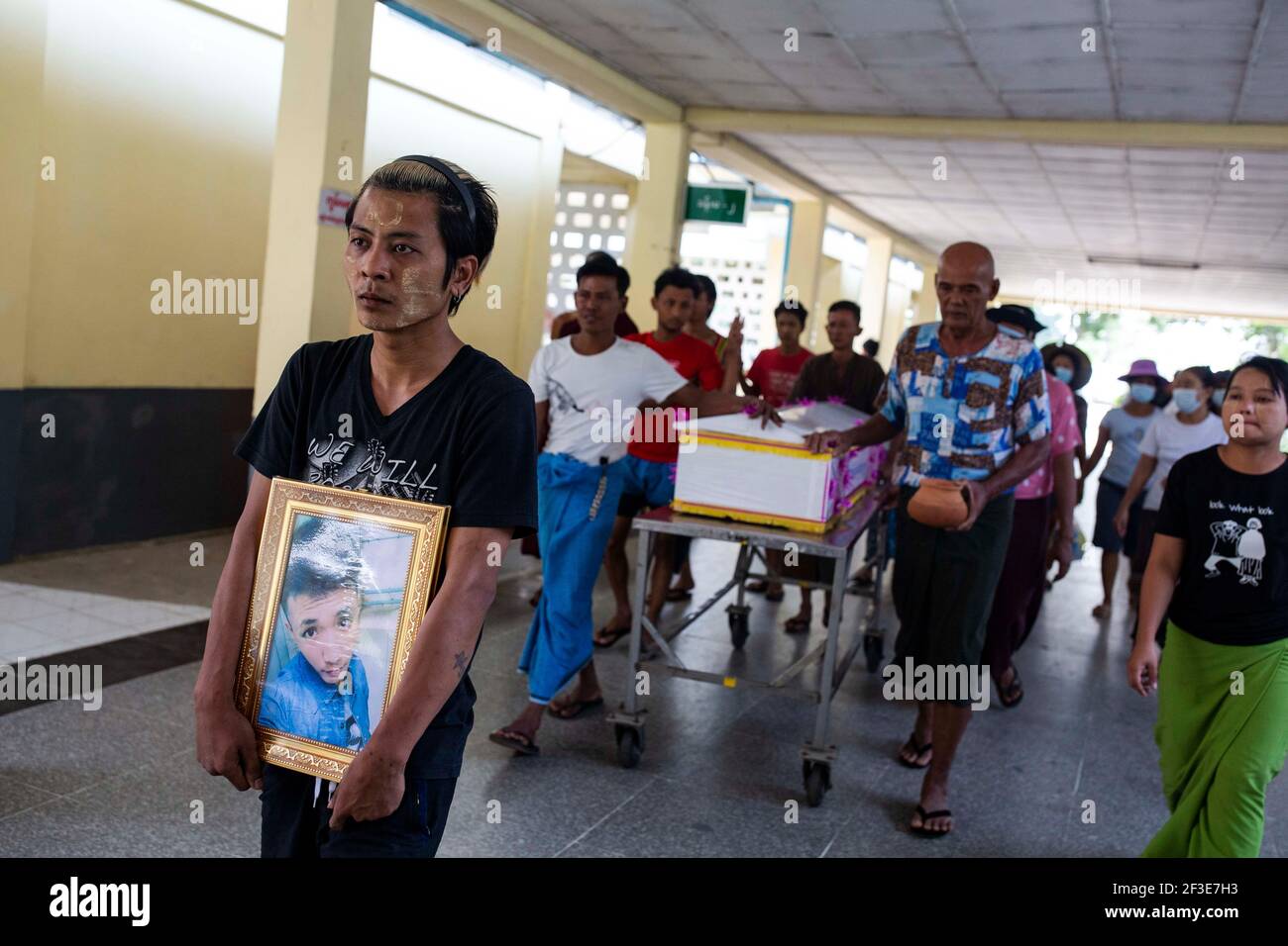 Un parente conserva il ritratto di un uomo ucciso il 14 marzo dalle forze di sicurezza dopo che hanno aperto il fuoco verso pacifici manifestanti anti di colpo di stato anti-militare a Yangon.la polizia di Myanmar ha attaccato i manifestanti con proiettili di gomma, munizioni vive, gas lacrimogeni e bombe stordite in risposta ai dimostranti anti di colpo di stato militare la domenica (14 marzo), uccidendo oltre 70 manifestanti e ferendo molti. L'esercito del Myanmar ha arrestato il consigliere di Stato del Myanmar Aung San Suu Kyi il 01 febbraio 2021 e ha dichiarato uno stato di emergenza mentre cogliendo il potere nel paese per un anno dopo aver perso l'elezione contro la Lega nazionale f Foto Stock