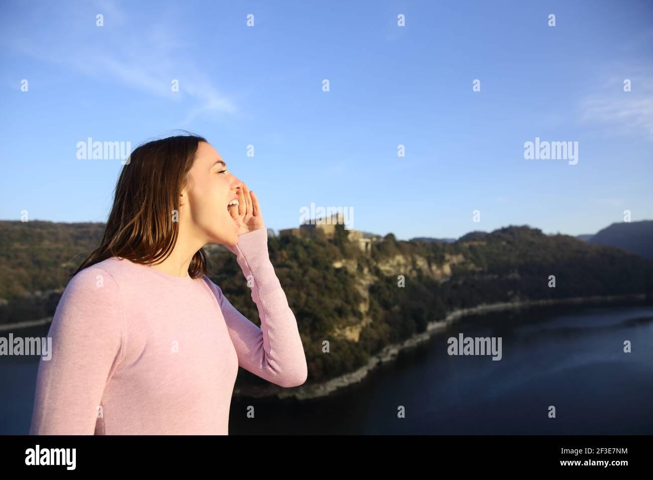 Profilo di una donna felice urlando in montagna vacanza Foto Stock