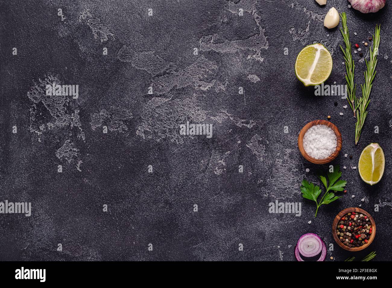 Erbe e condimenti su fondo di pietra nera. Vista dall'alto con spazio per la copia. Foto Stock