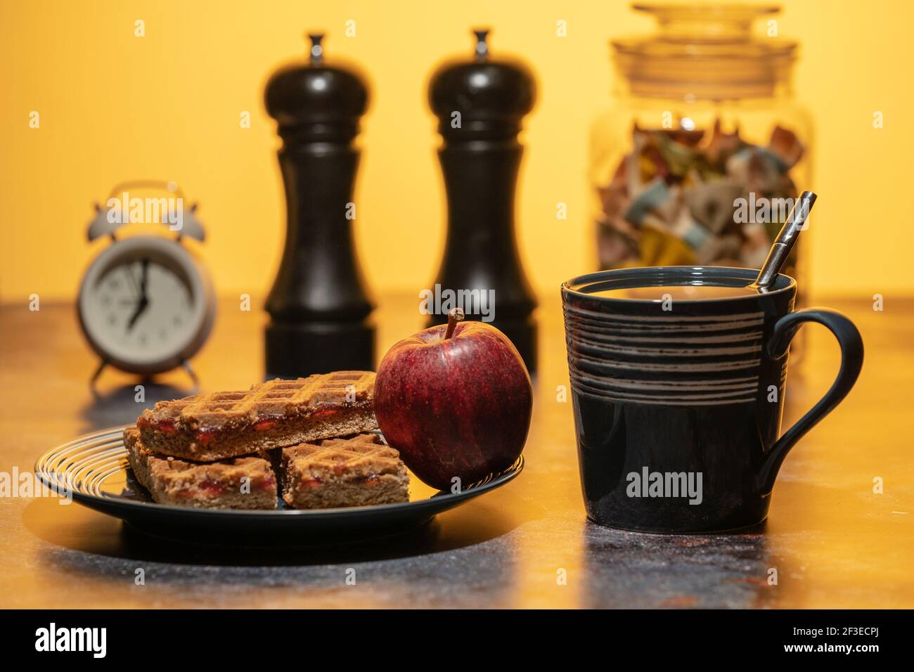 Una tazza di tè e un piatto di biscotti e mela in piedi sul tavolo. Colazione Foto Stock