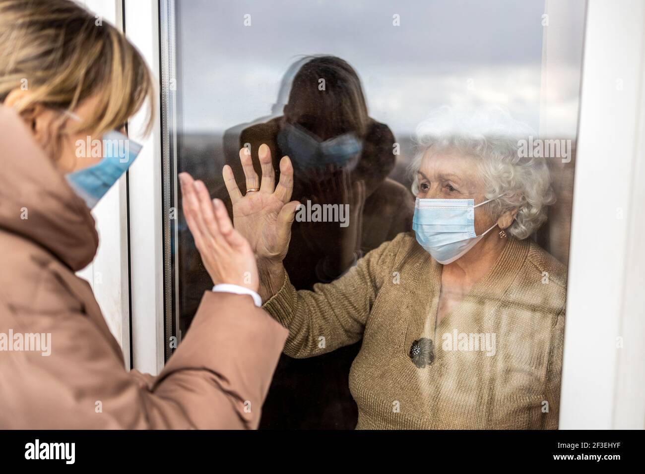 Donna che visita la nonna in isolamento durante una pandemia di coronavirus Foto Stock