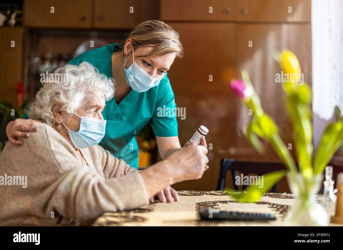 Assistente domestico che aiuta la donna anziana con il farmaco Foto Stock