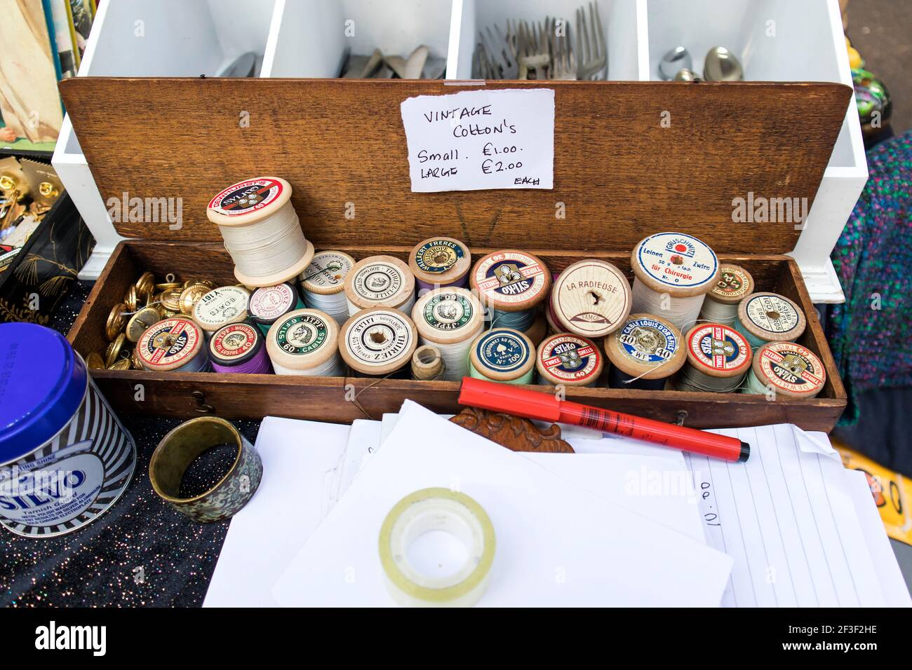 Liverpool Street, Londra, Regno Unito, 21 settembre 2020, mercato dell'antiquariato di Spitalfields. Tutto per cucire: Bobine di filo in una scatola di legno. La casella dice - Foto Stock