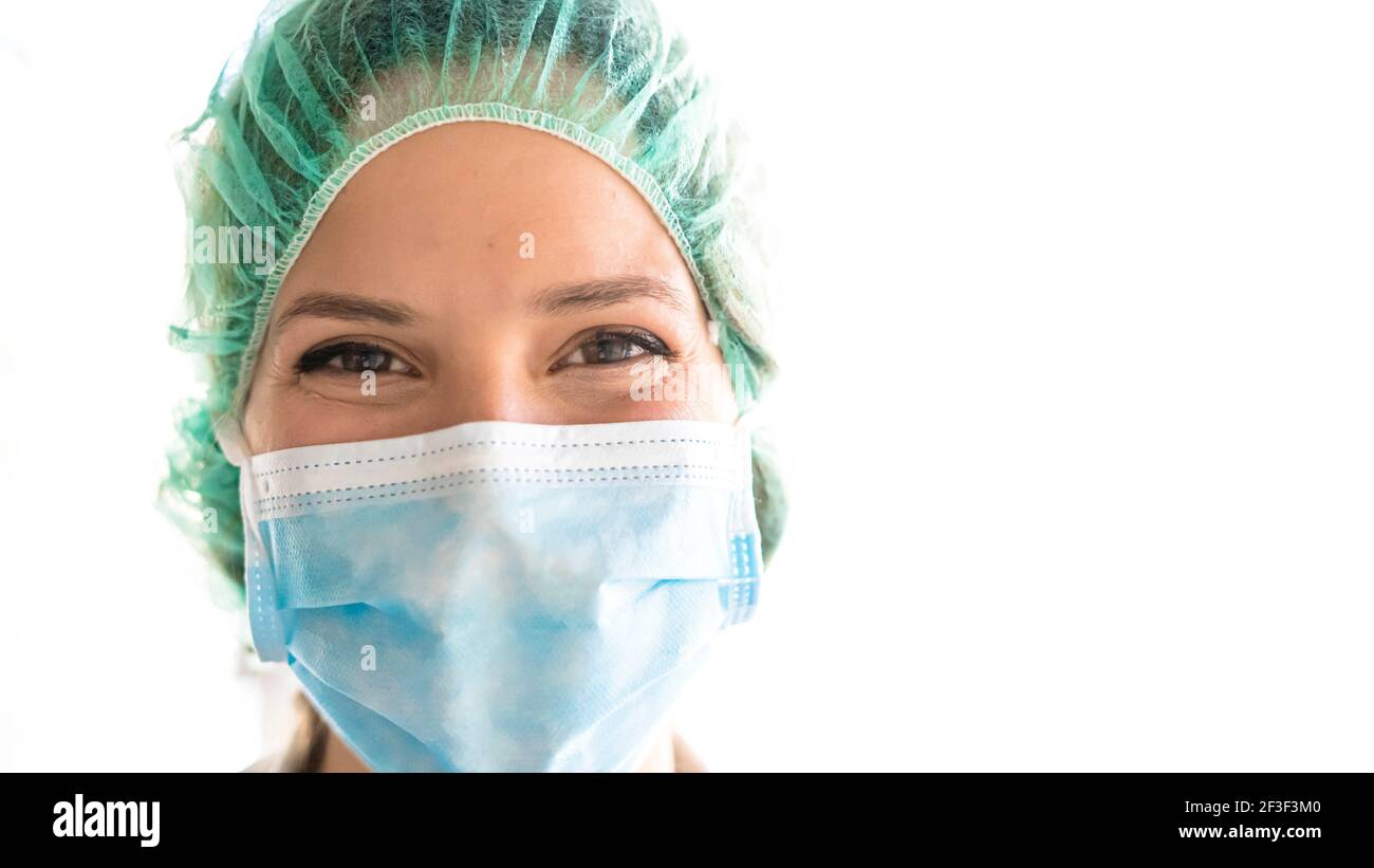 Giovane medico professionista sorriso con maschera di procedura sul viso Foto Stock