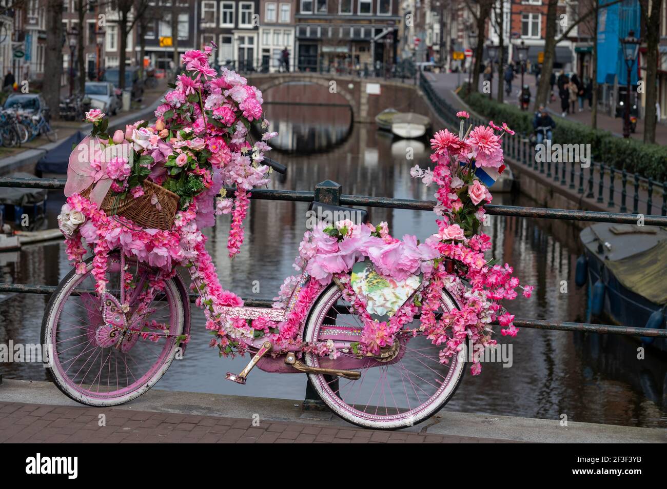 Vecchia bicicletta donna vintage decorata con fiori rosa su piccola ponte  nella parte vecchia di Amsterdam Foto stock - Alamy