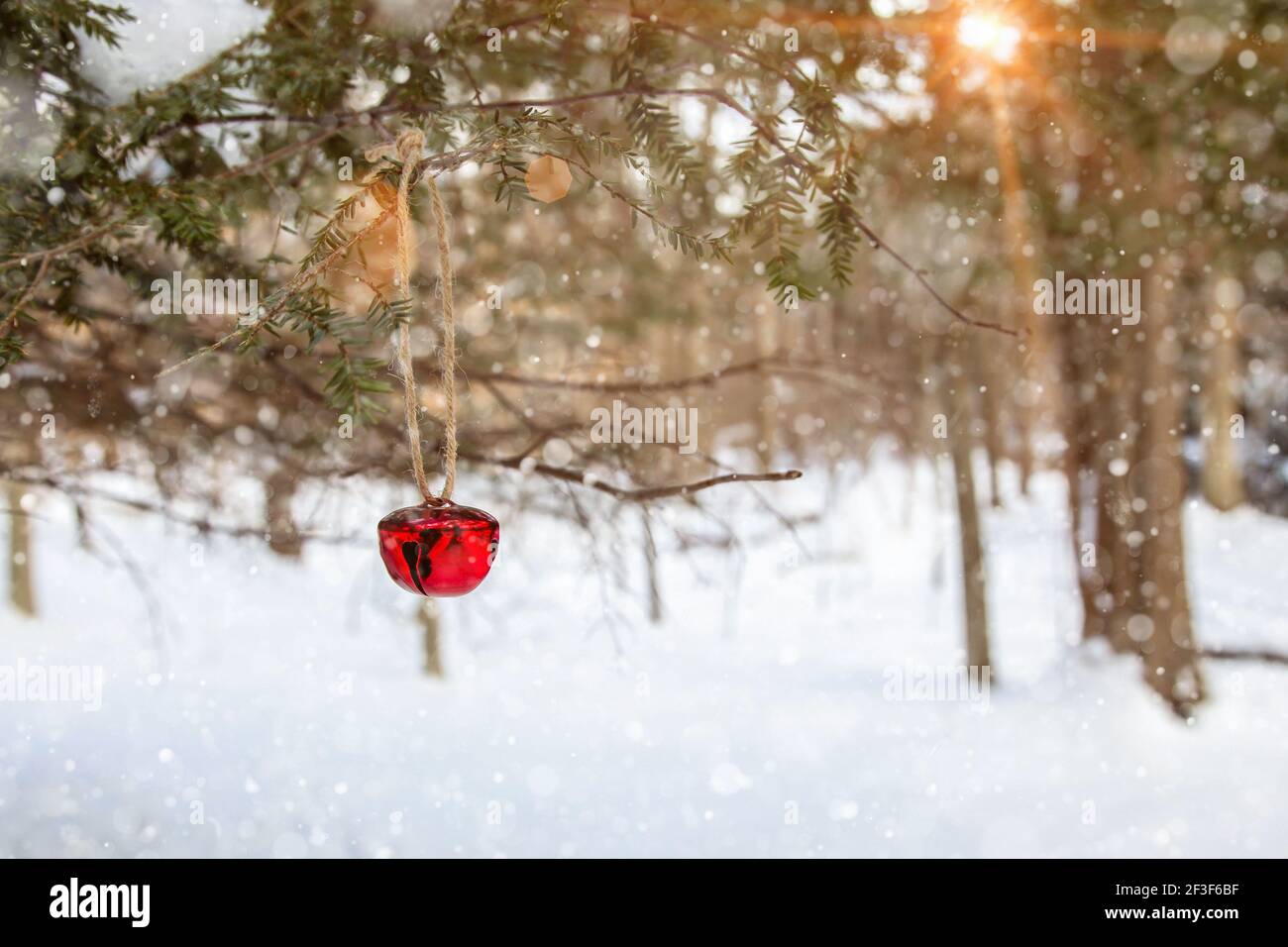 Jingle campana su albero con paesaggio invernale in background con neve artificiale Foto Stock