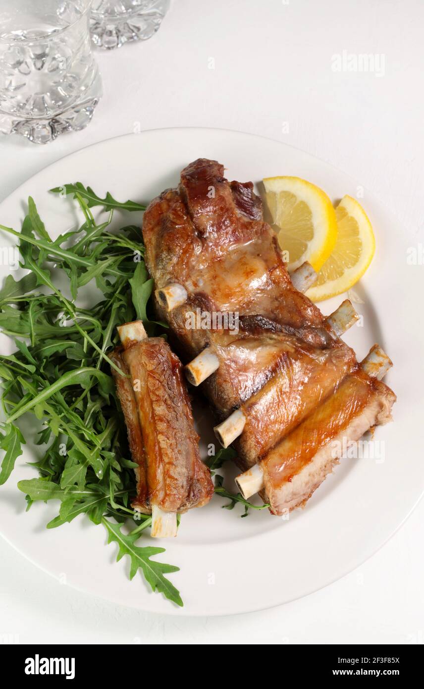 Costolette fritte con insalata fresca su piatto bianco. Direttamente sopra. Spazio di copia. Foto Stock