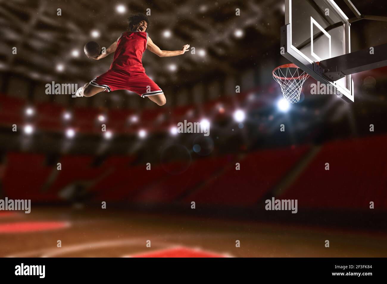 Gioco di pallacanestro con un giocatore di salto alto per fare un slam dunk al cesto Foto Stock