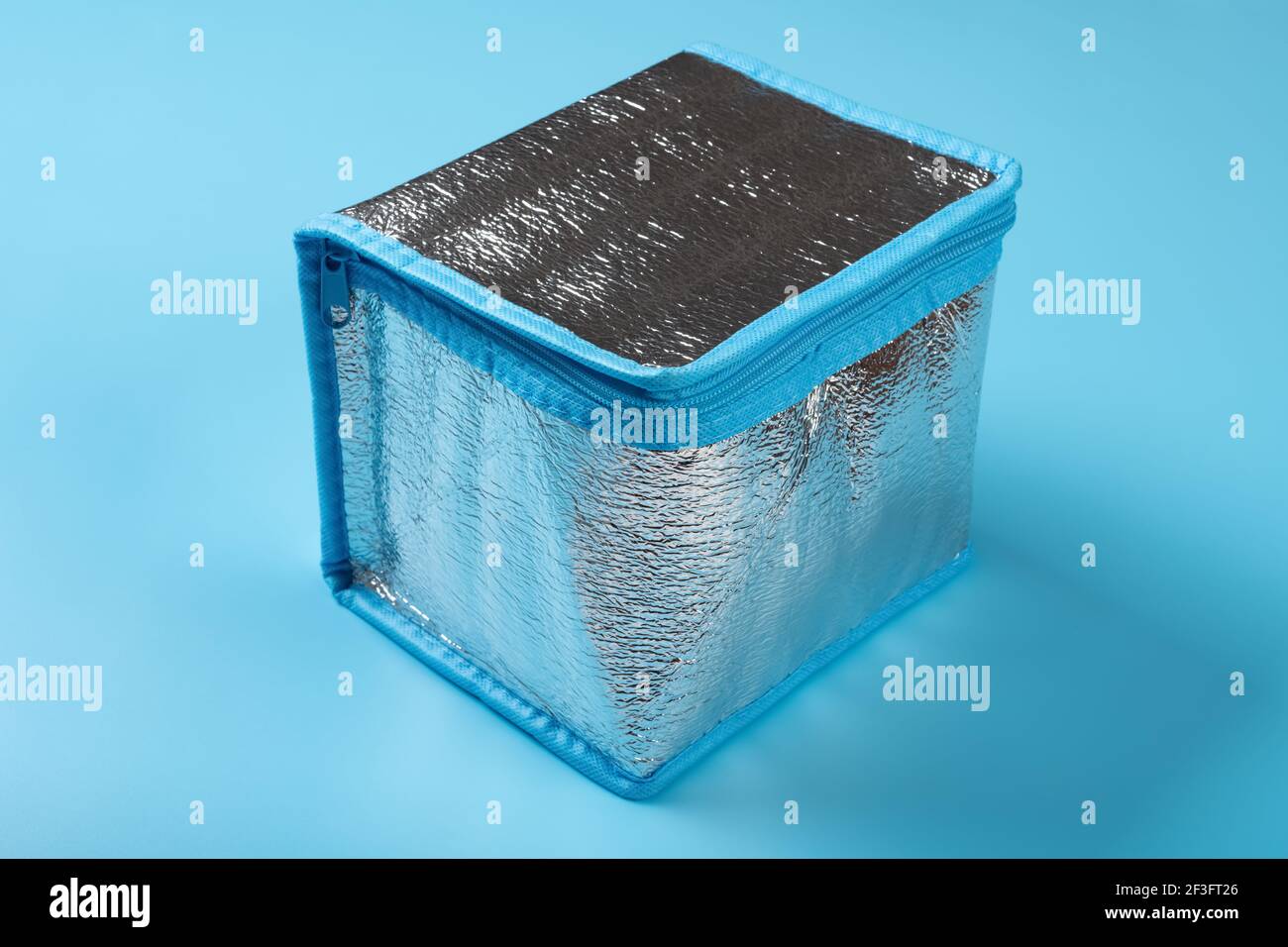 una piccola sacca isolante su sfondo blu Foto Stock