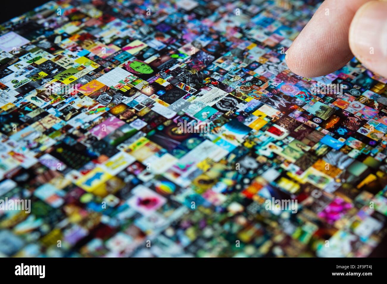 Dito che punta verso lo schermo del tablet con motivo Beeple " EVERYDAYS: THE FIRST 5000 DAYS". Collage art firmato con token NFT. Concetto. Foto Stock