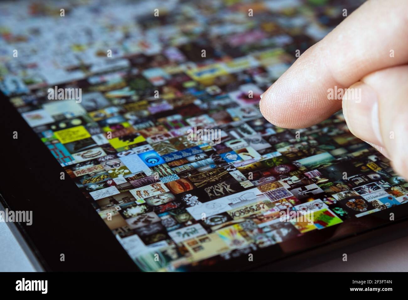 Dito che punta verso lo schermo del tablet con motivo Beeple " EVERYDAYS: THE FIRST 5000 DAYS". Collage art firmato con token NFT. Concetto. Foto Stock